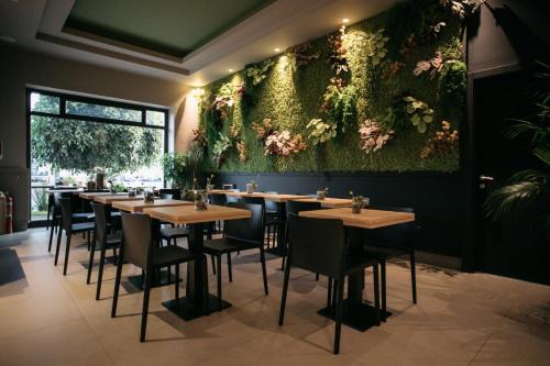 a row of tables in a restaurant with flowers on the wall at Hotel Aloisi in Lecce