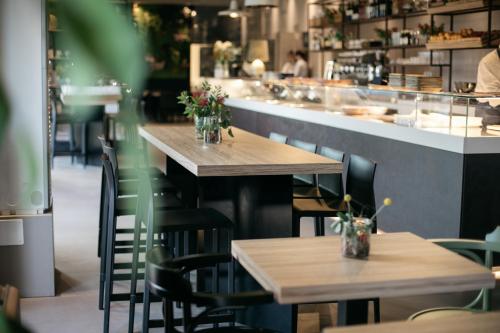 a restaurant with wooden tables and chairs and a counter at Hotel Aloisi in Lecce