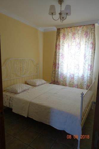a bedroom with a bed with a curtain and a window at Princ Gabi in Málaga