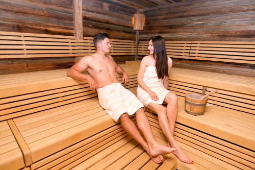 a man and a woman sitting on a bench at Salzburg Hotel Holznerwirt in Eugendorf