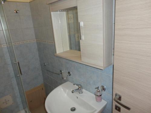 a bathroom with a sink and a mirror and a shower at Anema e Core Pizzo in Pizzo