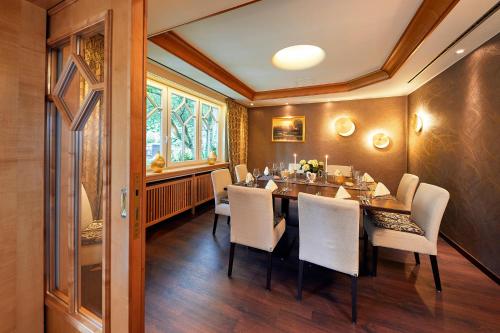 a dining room with a table and white chairs at Engemann Kurve in Winterberg