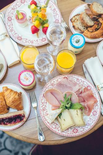 een houten tafel met borden met eten erop bij Hôtel Alfred Sommier in Parijs
