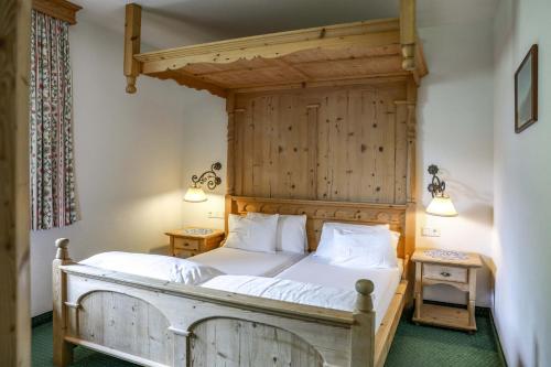 a bedroom with a bed with a wooden headboard at Alpenromantik-Hotel Wirlerhof in Galtür