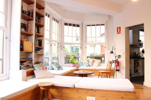 a living room with a white couch and windows at Aloha Hostel in Pamplona