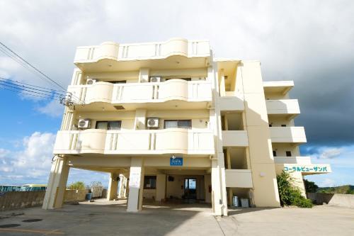 a tall white building with white balconies on it at Yomitan Ocean View Apartment 403 in Yomitan