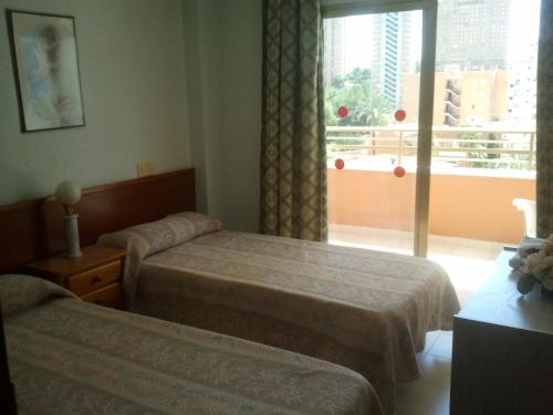a hotel room with two beds and a window at Apartamentos Ocaña in Cala de Finestrat
