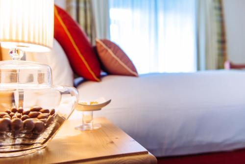 a glass bowl of rocks on a table next to a bed at Schloss Hotel & Spa Pontresina in Pontresina