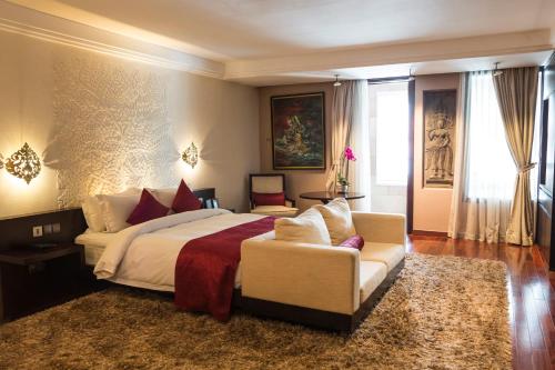 a bedroom with a large bed and a couch at Arunreas Hotel in Phnom Penh