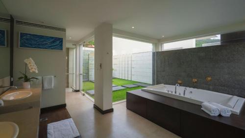 a bathroom with a large tub and a large window at Villa Princess Stephanie in Kata Beach