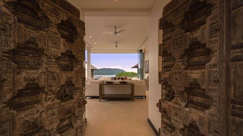 a hallway with a stone wall with a view of the ocean at Villa Princess Stephanie in Kata Beach