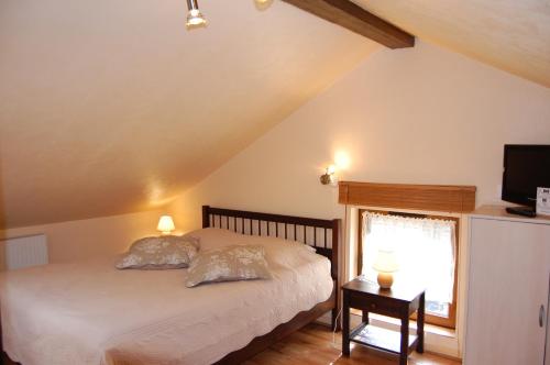 1 dormitorio con 1 cama con 2 almohadas y ventana en AUBERGE du BORD des EAUX - Demi-pension assurée sur réservation en Saint-Amand-les-Eaux