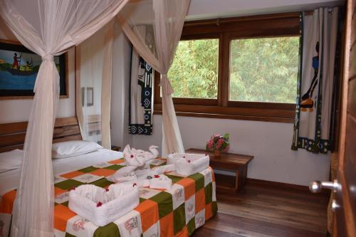 a bedroom with a bed with towels on it at Hotel Club du Lac Tanganyika in Bujumbura