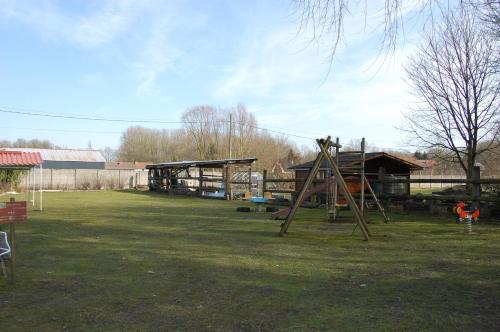 un parc avec une aire de jeux avec une structure de jeux dans l'établissement AUBERGE du BORD des EAUX - Demi-pension assurée sur réservation, à Saint-Amand-les-Eaux