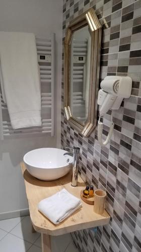 une salle de bain avec un lavabo et un miroir dans l'établissement La Maison Blanche, à Blaye