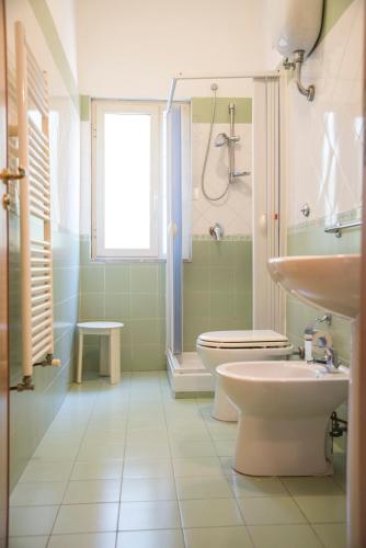 a bathroom with a toilet and a shower and a sink at Hotel Eden in Perdifumo