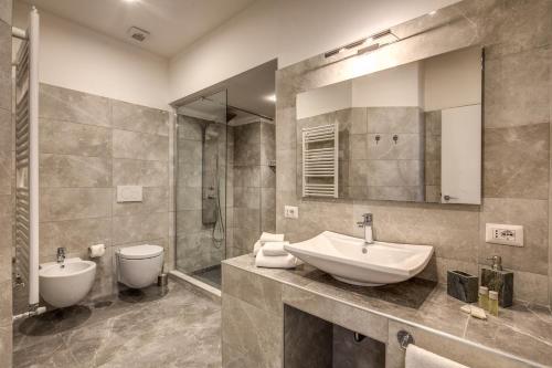 bagno con lavandino, servizi igienici e specchio di The Spanish steps apartment 67 a Roma