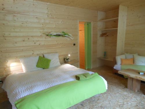 1 dormitorio con 1 cama grande en una pared de madera en L'Atelier de Gisèle, en Oberhaslach