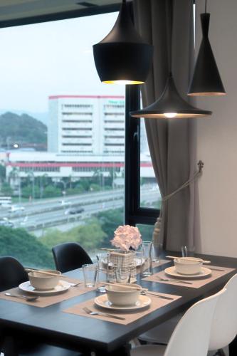 a table with chairs and a table with a window at Cozy Living Sky Apartment in Kota Kinabalu