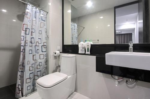 a bathroom with a white toilet and a sink at Cozy Living Sky Apartment in Kota Kinabalu