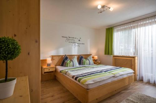 a bedroom with a wooden bed with a green curtain at Berghof Geisler in Finkenberg