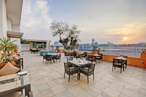 a restaurant with tables and chairs on a balcony at Lemon Tree Premier “The Atrium” Ahmedabad in Ahmedabad