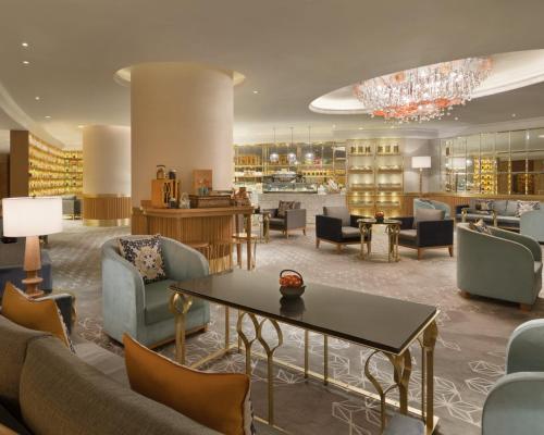 a lobby with couches and a table and chairs at Shangri-La Eros New Delhi in New Delhi
