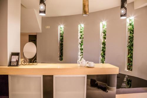 a bathroom with a counter with a sink and mirrors at Zdrojówka Noclegi in Kleosin