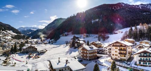 a village covered in snow with mountains in the background at Garni Rives in Ortisei