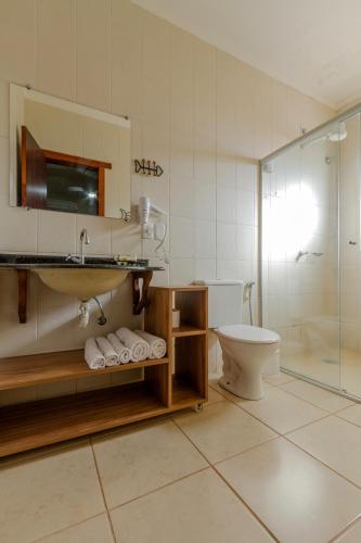 a bathroom with a toilet and a sink and a shower at Pousada Chamamé in Bonito