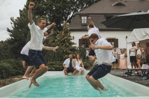 Eine Gruppe Männer springt in ein Schwimmbad in der Unterkunft Sancta Katharina in Rozvadov