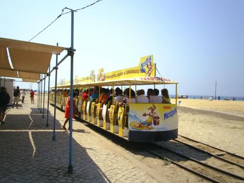 a trolley filled with people riding on the beach at Lisbon Beach Apartments 6 in Costa da Caparica