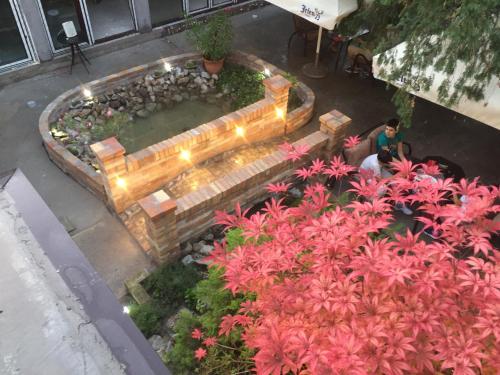 an overhead view of a fountain in a garden with pink flowers at Garden House in Apatin