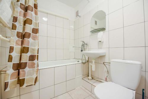 La salle de bains blanche est pourvue de toilettes et d'un lavabo. dans l'établissement KTU Rest House Politechnika, à Palanga