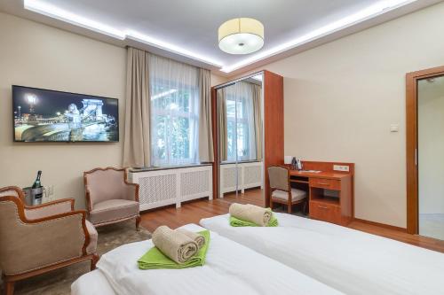 a hotel room with two beds and a desk at CityPark Deluxe Apartment in Budapest