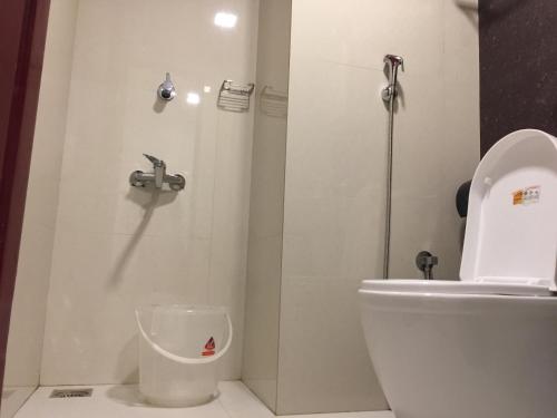 a bathroom with a white toilet and a shower at Temple Plaza Kochi in Chottanikara