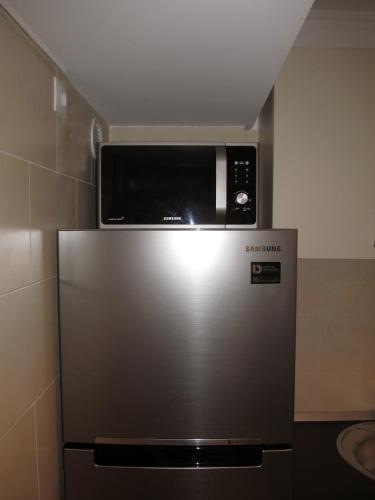 a microwave on top of a stainless steel refrigerator at My Little Studio in Bucharest