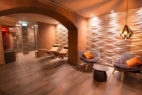 a lobby with chairs and a wall with a fireplace at Top Hotel Hammer - Mainz Hauptbahnhof in Mainz