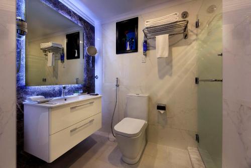 a bathroom with a toilet and a sink and a shower at Coral Jubail Hotel in Al Jubail