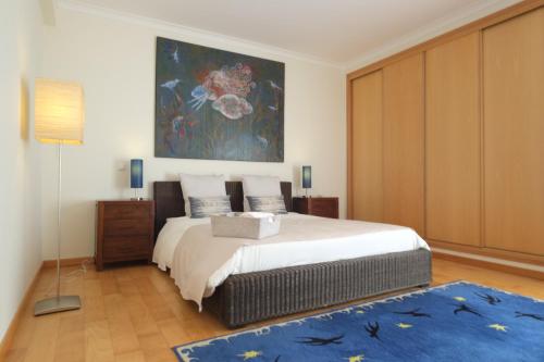 - une chambre avec un lit et une peinture murale dans l'établissement Alto da Ria 37, à Alvor