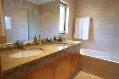 a bathroom with two sinks and a bath tub at Alto da Ria 37 in Alvor