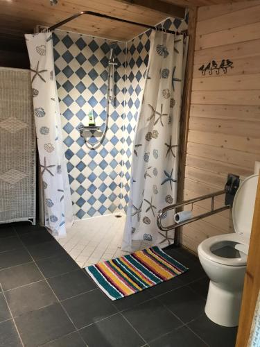 a bathroom with a shower with a toilet and a rug at Cotswolds Camping at Holycombe in Shipston-on-Stour