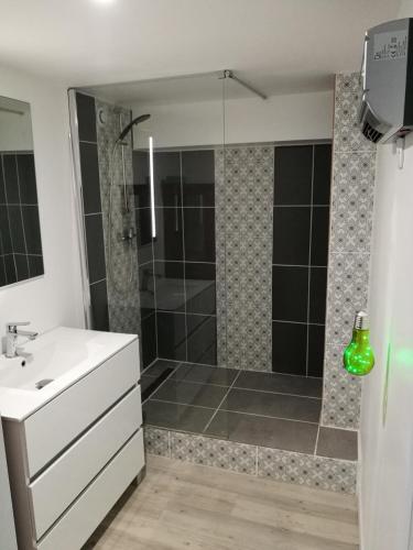 une salle de bain avec une douche avec un lavabo et une baignoire dans l'établissement Maison au Calme Climatisée avec spa de mai à fin septembre, à Royan