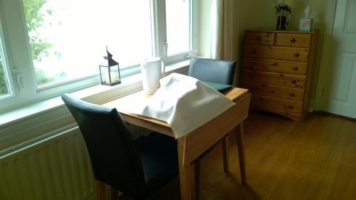 a desk with a laptop and a chair in front of a window at The Townhouse in Elphin