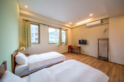 um quarto de hospital com duas camas e uma janela em 7-113 hotel em Shoufeng