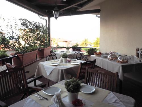 un restaurante con mesas con manteles blancos en B&B Ulisse, en Roccella Ionica