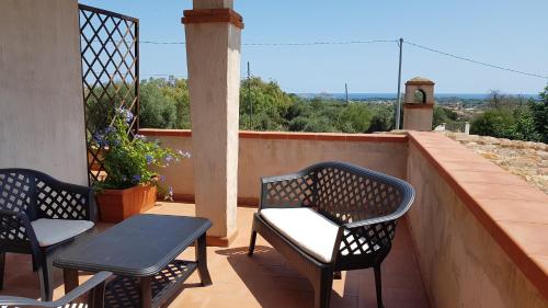 a patio with two chairs and a table on a balcony at Casa Sa serra in Lotzorai