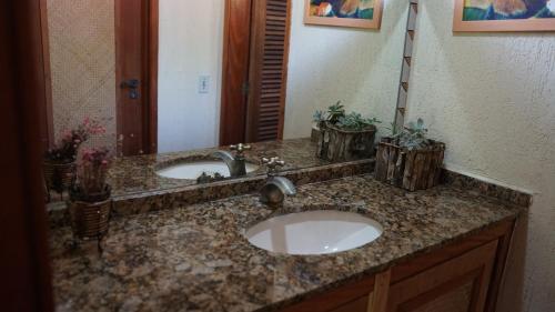 a bathroom counter with two sinks and a mirror at Pousada Cabanas da Serra Lumiar in Lumiar