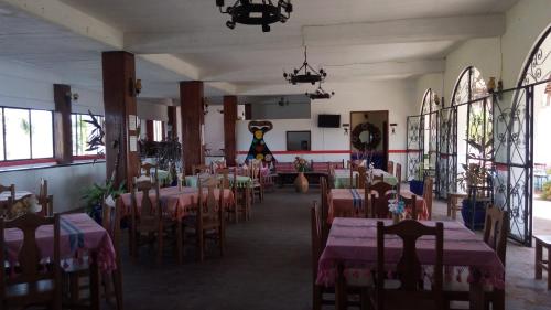 uma sala de jantar com mesas e cadeiras num quarto em Angel del Mar em Puerto Ángel