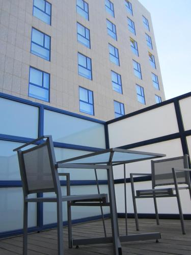 two chairs and a table in front of a building at Primus Valencia in Valencia